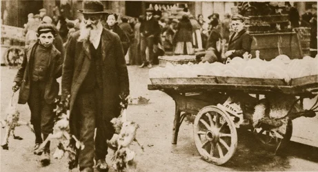 Ein jüdischer alter Mann und sein Enkel tragen Geflügel von der Wentworth Street, Stepney